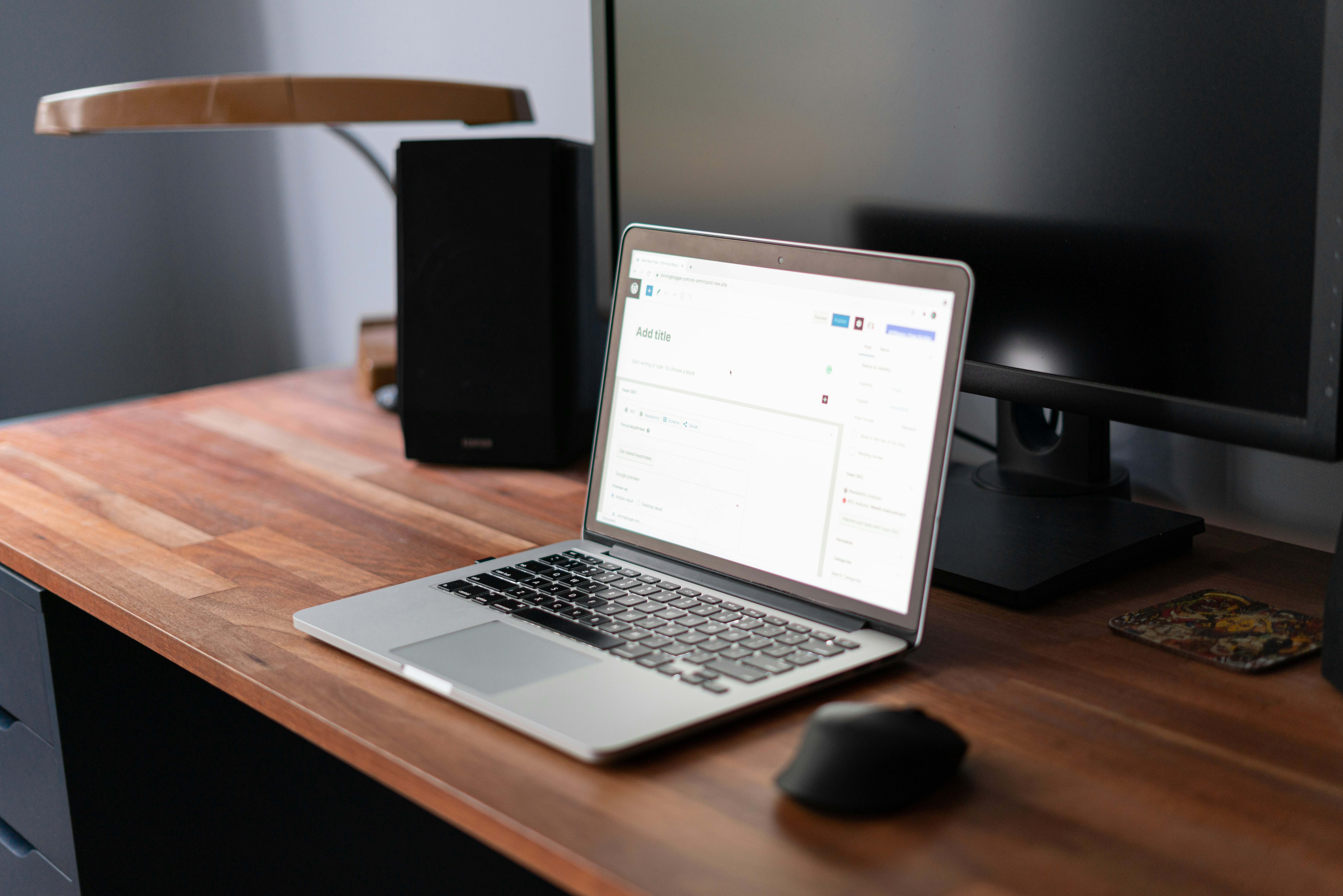 MacBook open on a wooden desk, mid-writing session